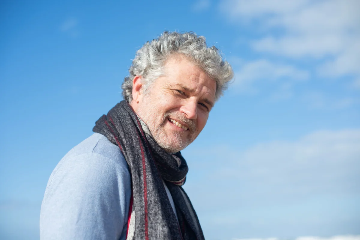 Healthy middle aged man smiling outside.