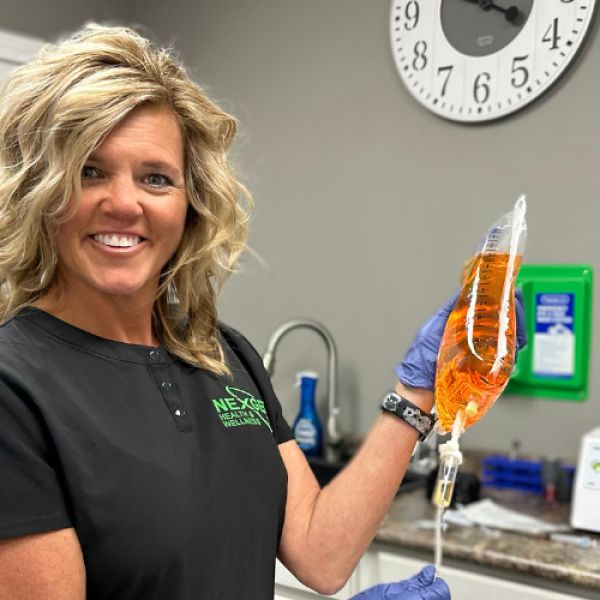 Owner of NexGen holding an IV bag.
