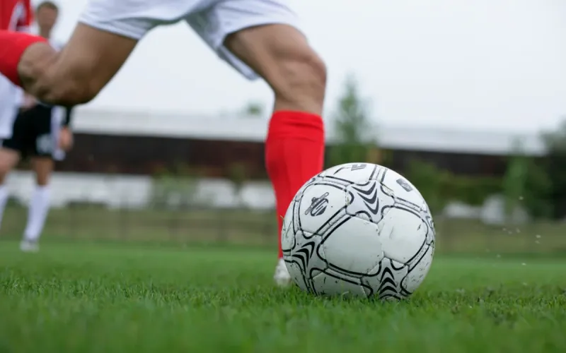 A soccer player kicking the ball.