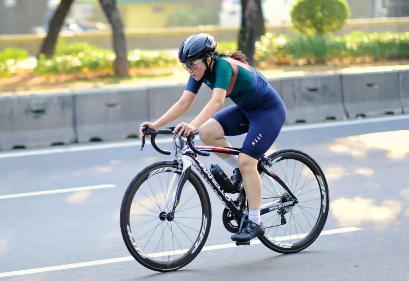 Woman riding bike in the sunshine.