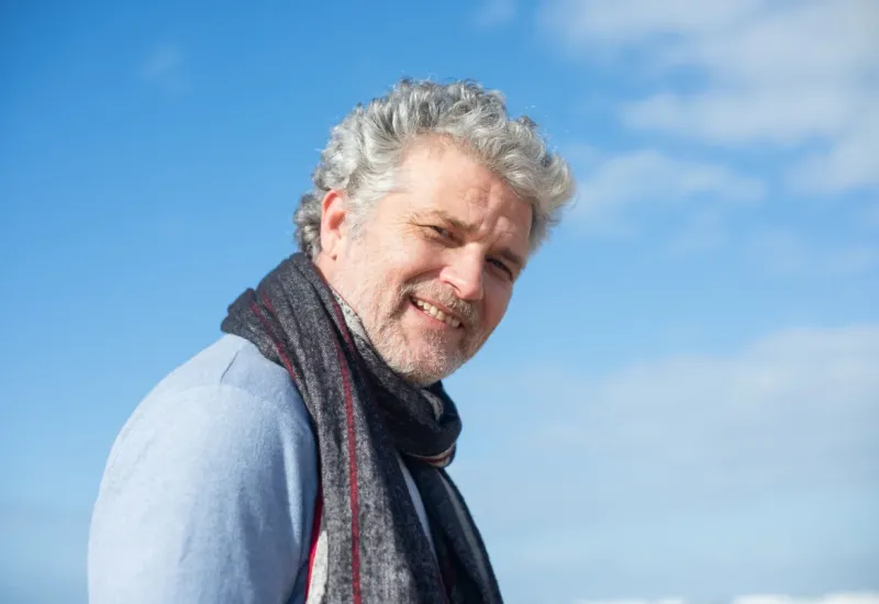 Healthy middle aged man smiling outside.
